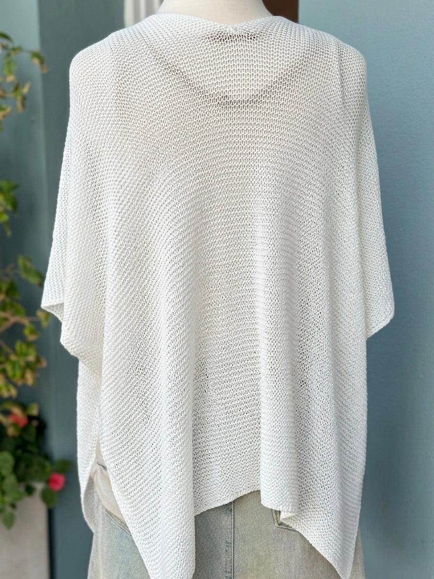 Back view of the Elise Wrap Poncho in White on a mannequin, showing its open-knit texture and pointed hem.
