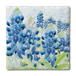A square decorative tile or coaster featuring a watercolor-style floral print of blue lupines with green leaves on a white dotted background, shown against a plain white backdrop.