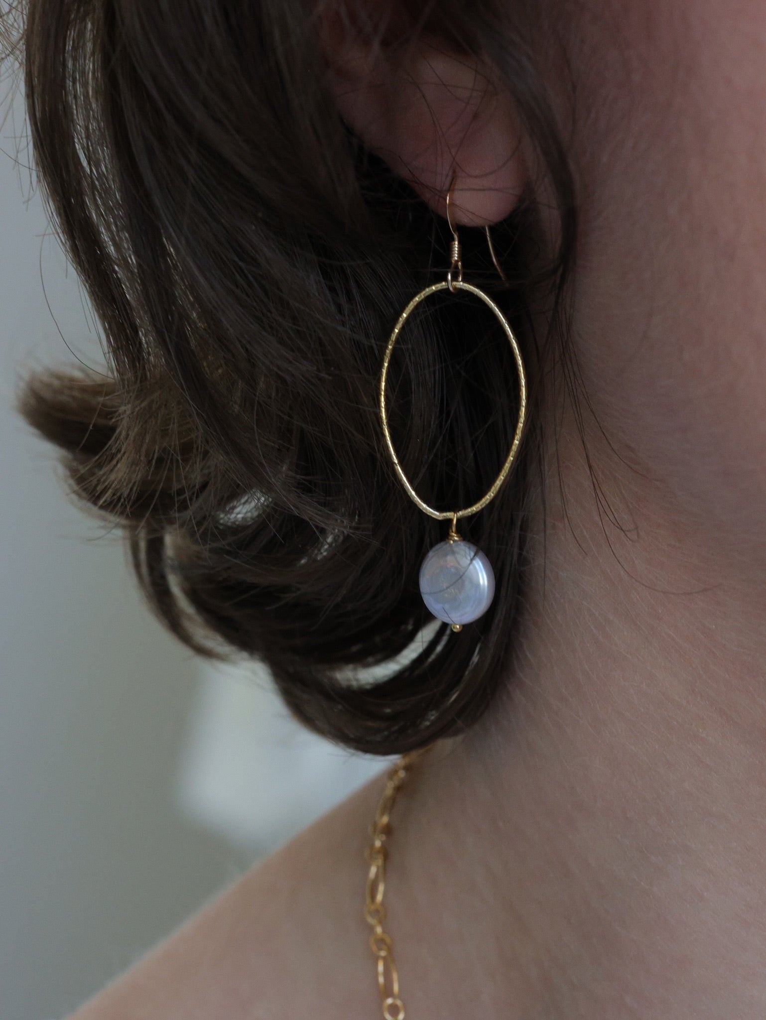 "Model wearing Nina Hall gold oval earring with soft grey coin pearl from Ardor Boutique, handmade in the USA and nickel-free
