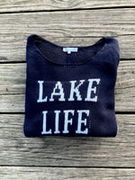 Cotton acrylic navy Lake Life sweater folded on wooden dock from Ardor Boutique