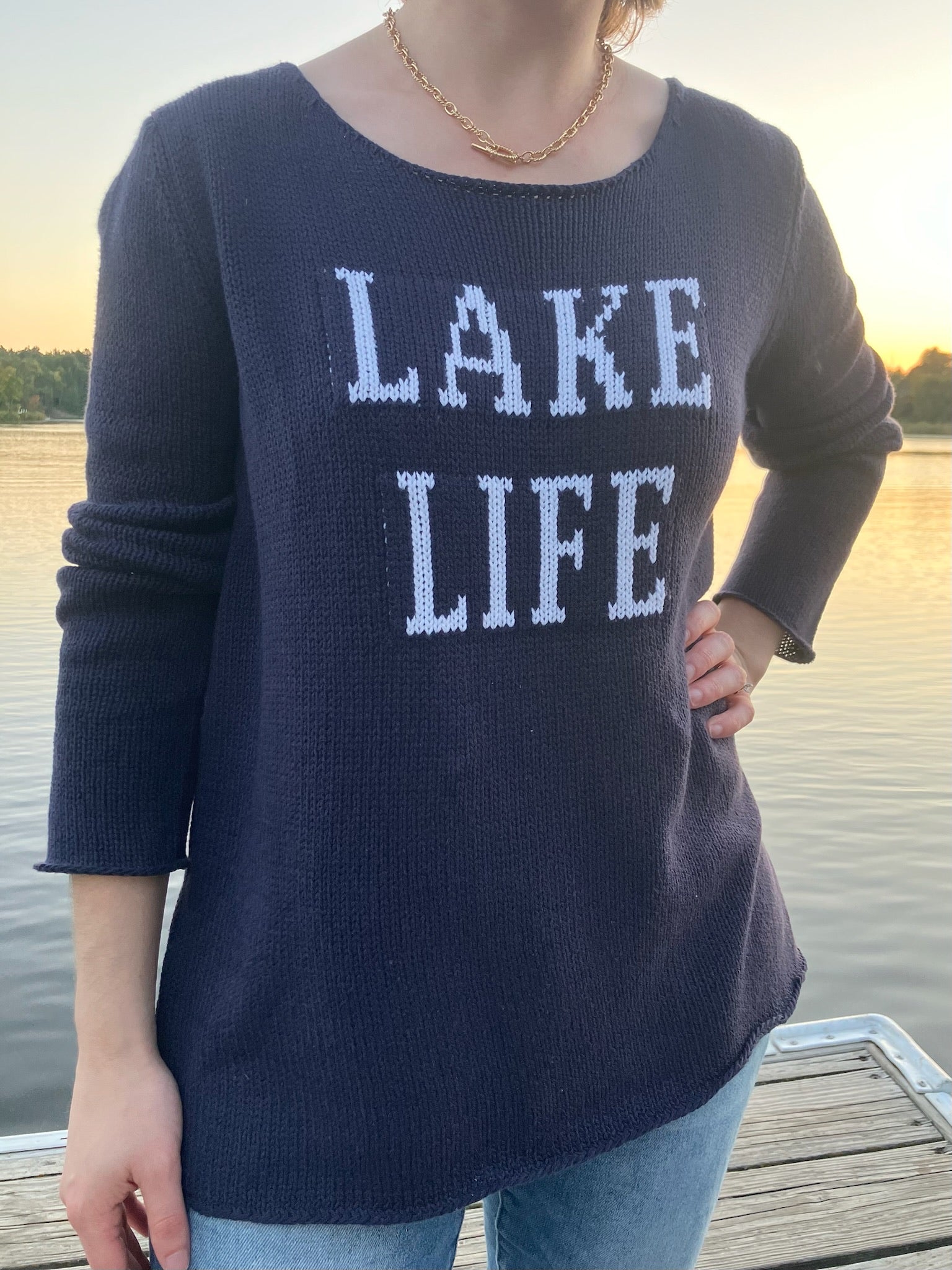 Cotton acrylic navy Lake Life sweater with ivory lettering, front view at lakeside from Ardor Boutique