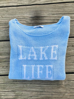 Cotton acrylic sky blue Lake Life sweater folded on wooden dock from Ardor Boutique