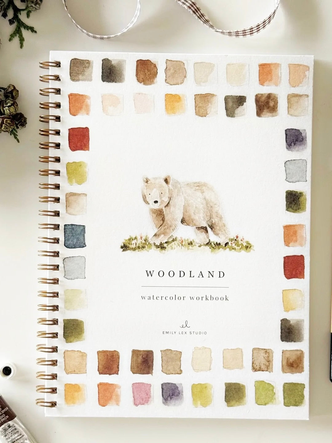 Woodland Watercolor Workbook front cover with watercolor bear and color palette border, spiral bound by Emily Lex