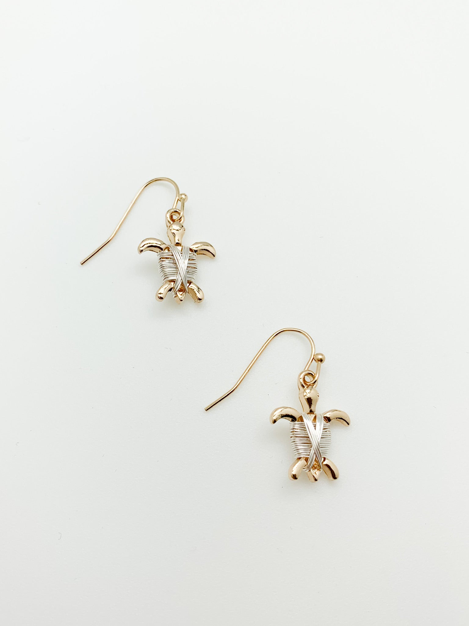 Nylah mixed metal turtle earrings. gold turtles with silver wire wrapping.