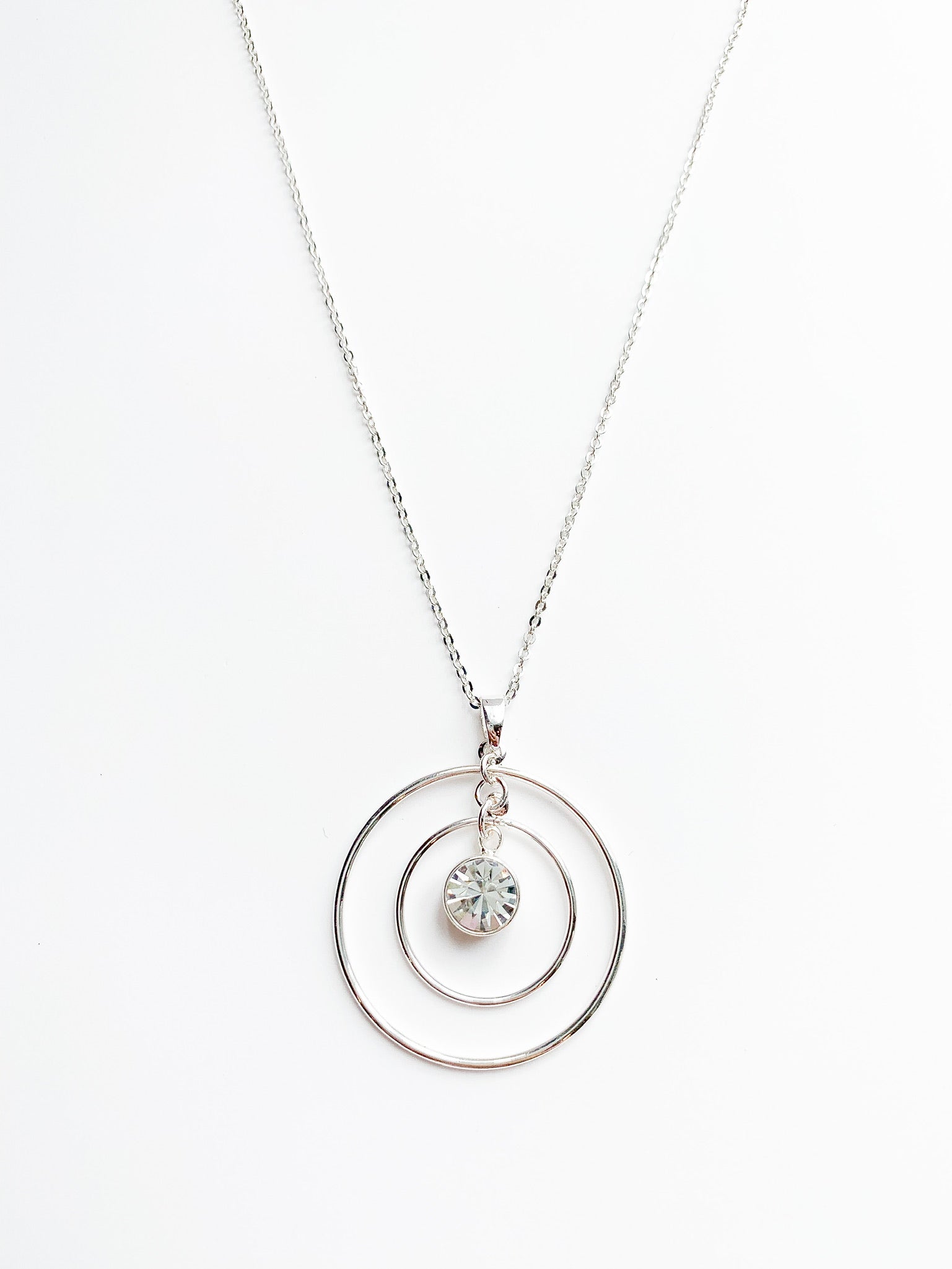 danielle long silver necklace. 2 halos around a crystal pendent.