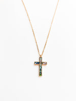Delicate gold necklace featuring a cross pendant with luminous abalone shell inlay, displaying natural ocean-inspired hues of blue, green, and pearl.