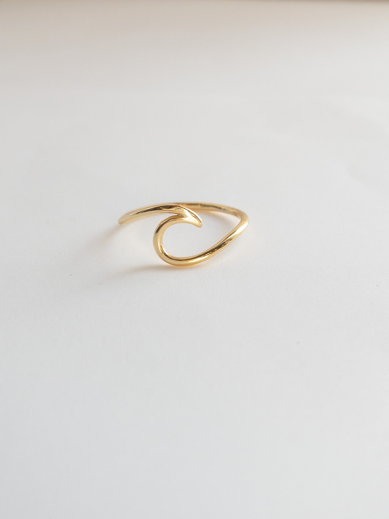 Gold sterling cresting wave ring on a white background 
